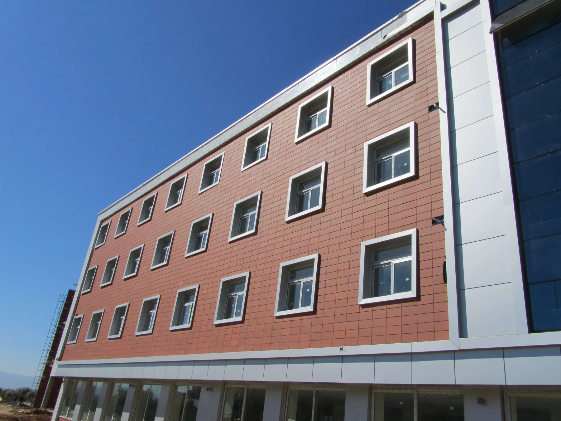 Terracotta panel façade with horizontal joints and framed windows